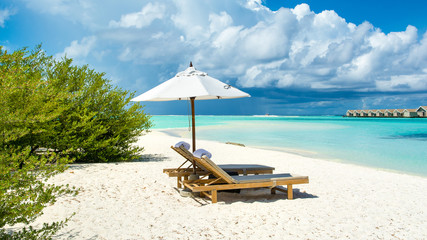 Beautiful landscape with sunbeds and umbrellas on the sandy beach, Maldives island © Myroslava