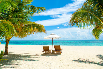 Naklejka na ściany i meble Beautiful landscape with sunbeds and umbrellas on the sandy beach, Maldives island