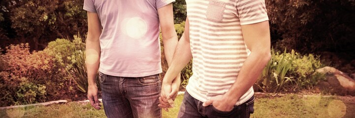 Smiling gay couple walking hand in hand 