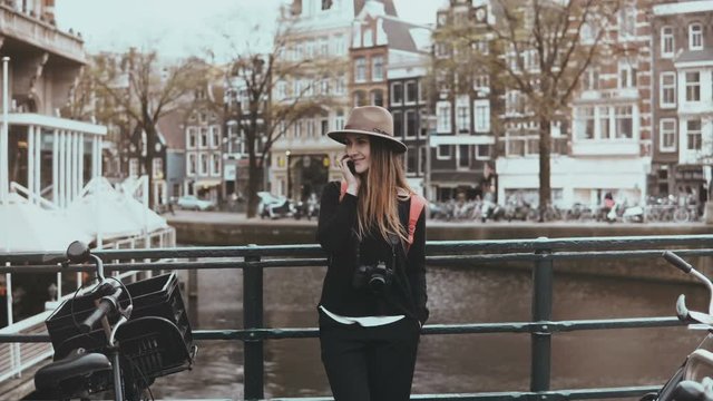 Portrait of cute European female make phone call. Zoom in. Happy to hear each other voice. Amsterdam, Netherlands. 4K.