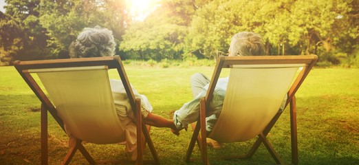 Happy mature couple sitting in park
