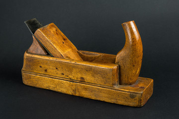 Old carpenter tool wood Plane on a gray