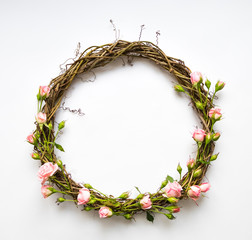 Festive wreath of vines with decorative roses, leaves. Flat lay, top view