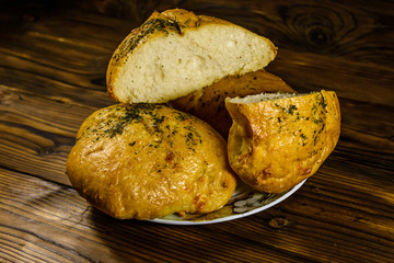 Plate with italian bun ciabatta on wooden table