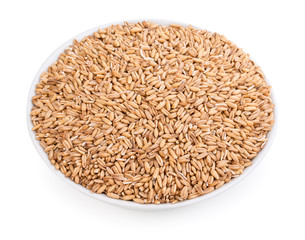 Whole oatmeal groats, oat grains, seeds, kernels, healthly diet food in a ceramic white bowl. Isolated on white background, close-up, top view.