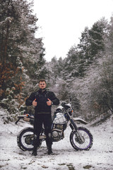 Fototapeta na wymiar Rider like man on a motorcycle Winter motocross. Skid on a snowy forest. the snow from under the wheels of a motorcycle Enduro. off road dual sport travel tour, active life style concept vertical