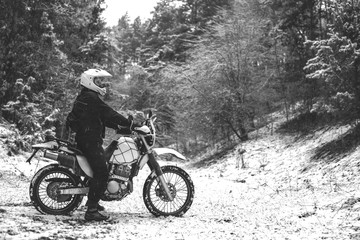 Fototapeta na wymiar Rider man on a motorcycle Winter motocross. Skid on a snowy forest. the snow from under the wheels of a motorcycle Enduro. off road dual sport travel tour, active life style concept black and white
