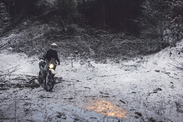 Rider man on a motorcycle Winter motocross. Skid on a snowy forest. the snow from under the wheels of a motorcycle Enduro. off road dual sport travel tour, active life style concept