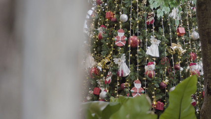 Greeting Season concept. Gimbal shot of ornaments on Christmas tree with decorative light and front home with door