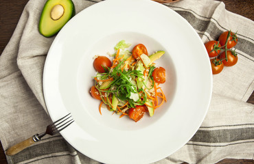 a beautifully served vegetarian salad with quinoa, salad leaves and cherry tomatoes on a white plate