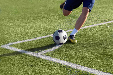 A football player strikes a football on the goal.