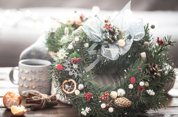 Christmas still life of trees and decorations, festive wreath on a background of knitted clothes and beautiful cups