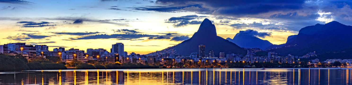 Panoramic image of dusk on the Rodrigo de Freitas lagoon in Rio de Janeiro with the sky and city lights reflecting in the water