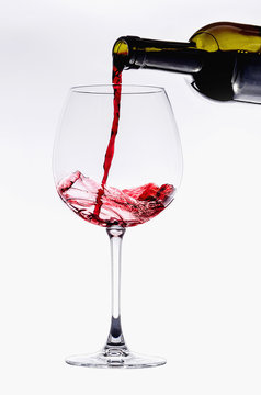 Pouring from wine bottle into an elegant crystal glass