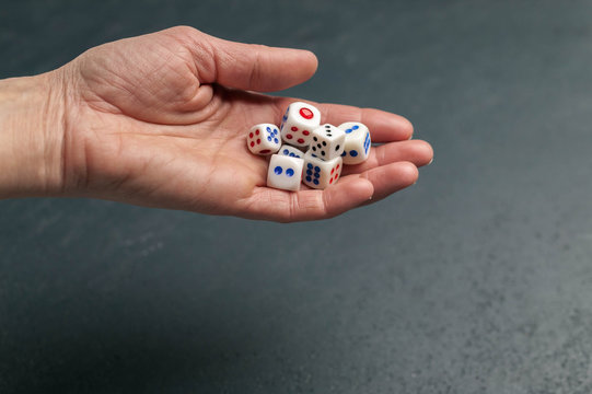 Dice. The female hand holds dice. Dark background