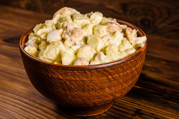 Salad with the haricot beans and meat dressed with mayonnaise in ceramic bowl