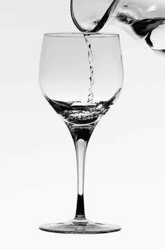 Detail of a crystal glass while pouring from a carafe fresh water