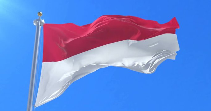 Flag of Monaco waving at wind in slow in blue sky, loop
