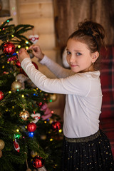 young girl deccorating christmas tree 