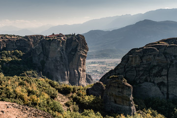 Monasteries are built on immense natural pillars and hill-like rounded boulders in Meteora, Greece 