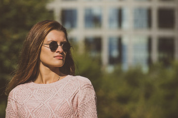 Beautiful young woman in round sunglasses on a bright sunny day