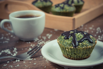 Vintage photo, Fresh muffins with spinach, desiccated coconut, chocolate glaze and cup of coffee