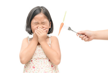 asian child girl with expression of disgust against vegetables