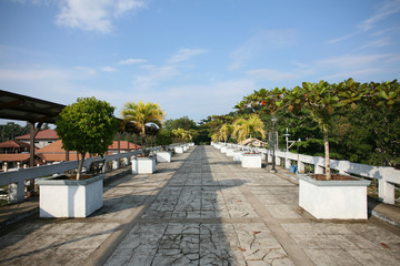 Evening shadows on a bridge over Loboc river lined with palm trees, in Loboc, Bohol, the Philippines