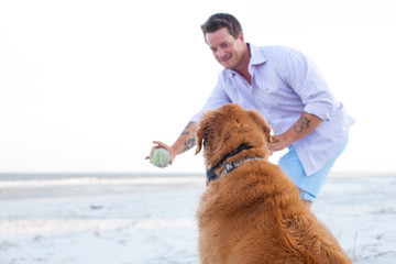 Man playing with dog on the beach