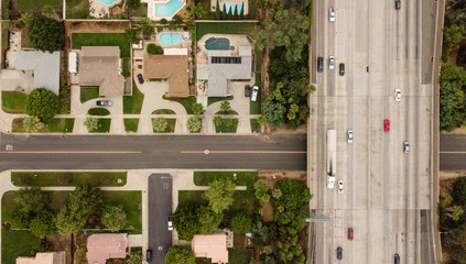 Obraz na płótnie Canvas Aerial sunset view of neighborhood and freeway in suburban Southern California