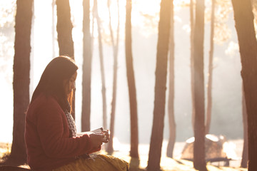 Young woman reading a book in the nature park with freshness in the morning with sunlight in vintage color tone