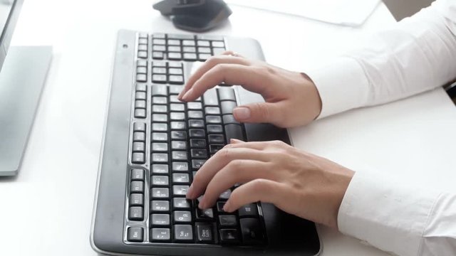 Closeup 4k footage of female hands typing on black computer keyboard