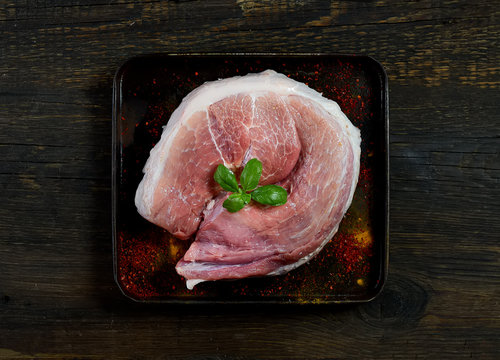raw meat on a baking sheet on a wooden background