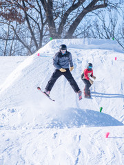 People are having fun in downhill skiing and snowboarding
