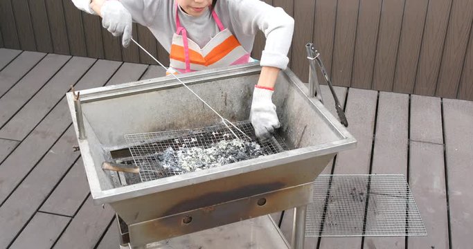 Housewife cleaning of barbecue oven