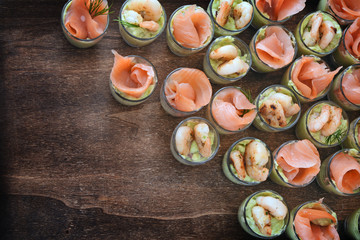 appetizer on the party buffet appetizervwith salmon and prawn shrimps in glasses on dark wood, top view from above, copy space