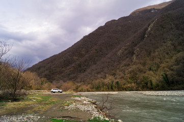 Белый автомобиль возле горной реки, декабрь, Абхазия.