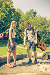 Hiking young couple with guitar backpack outdoor