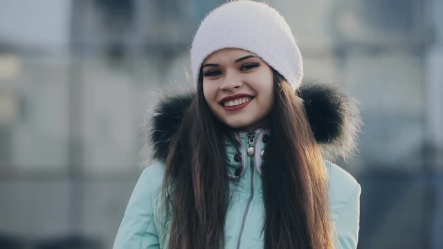 Smiling pretty girl portrait in white hat at winter day