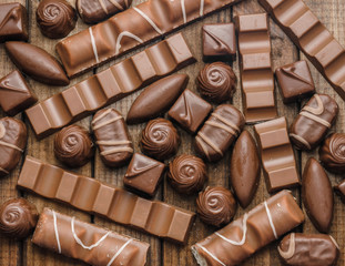 Background of chocolates, bars and sweets, free space for text, close up