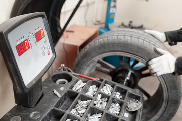 excellent balancing Wheel on zero. Technician spins a car wheel. The tool for repair - Lead small weights and pincers for Wheel Balancing. Car service.