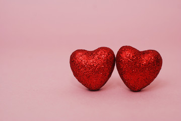 Close up of Two Shinny Valentines Hearts over Pink Background. Love and Heart Concept. Copy Space.