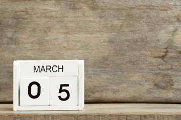 White block calendar present date 5 and month March on wood background