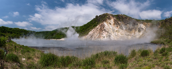 The hot water of Oyunuma pond in the volcanic landscape of Hell Valley (Jigokudani), Noboribetsu, Hokkaido, Japan
