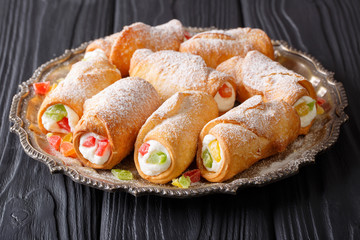 Sicilian cannoli with ricotta, candied fruits and powdered sugar close-up. horizontal