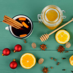 Hot red mulled wine on wooden background with spices, orange slice, anise and cinnamon sticks. Flat lay, top view.