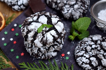 Chocolate crinkle cookies covered with sugar powder on a wooden board