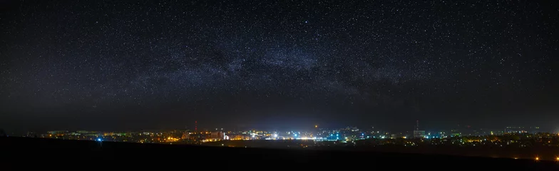Foto op Aluminium Panoramisch uitzicht op de sterrenhemel boven de stad. © olgapkurguzova