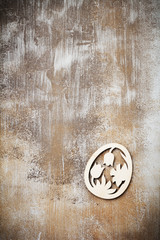 Symbols of Easter wooden decorative eggs and  rabbit on an old brown concrete or stone background. Selective focus. Top view. Place for text.