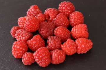 fresh red raspberriy fruits on a slate plate